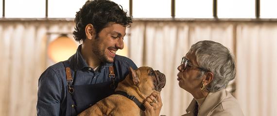 una signora anziana che da un bacio al cane che è tenuto in braccio da un uomo | Crédit Agricole una signora anziana che da un bacio al cane che è tenuto in braccio da un uomo | Crédit Agricole