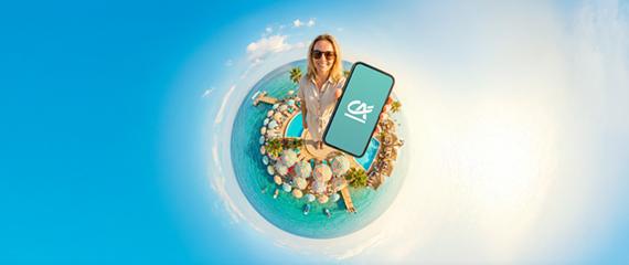Persona al centro di una piccola isola circolare circondata dal mare, con palme e elementi decorativi. La persona tiene in mano uno smartphone con il logo Crédit Agricole su sfondo azzurro. Sfondo dell’immagine con sfumatura dal blu al bianco. | Crédit Agricole Persona al centro di una piccola isola circolare circondata dal mare, con palme e elementi decorativi. La persona tiene in mano uno smartphone con il logo Crédit Agricole su sfondo azzurro. Sfondo dell’immagine con sfumatura dal blu al bianco. | Crédit Agricole