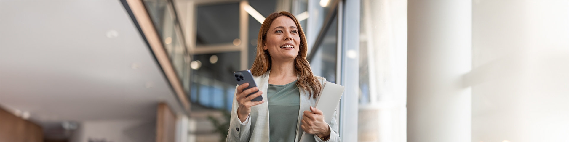 donna con smartphone in mano che guarda a destra | Crédit Agricole donna con smartphone in mano che guarda a destra | Crédit Agricole