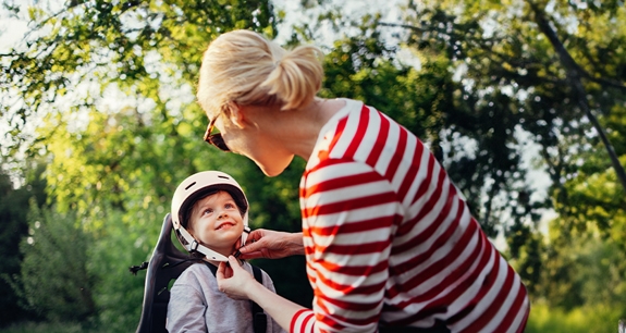donna che allaccia il casco a un bambino in bici | Crédit Agricole donna che allaccia il casco a un bambino in bici | Crédit Agricole