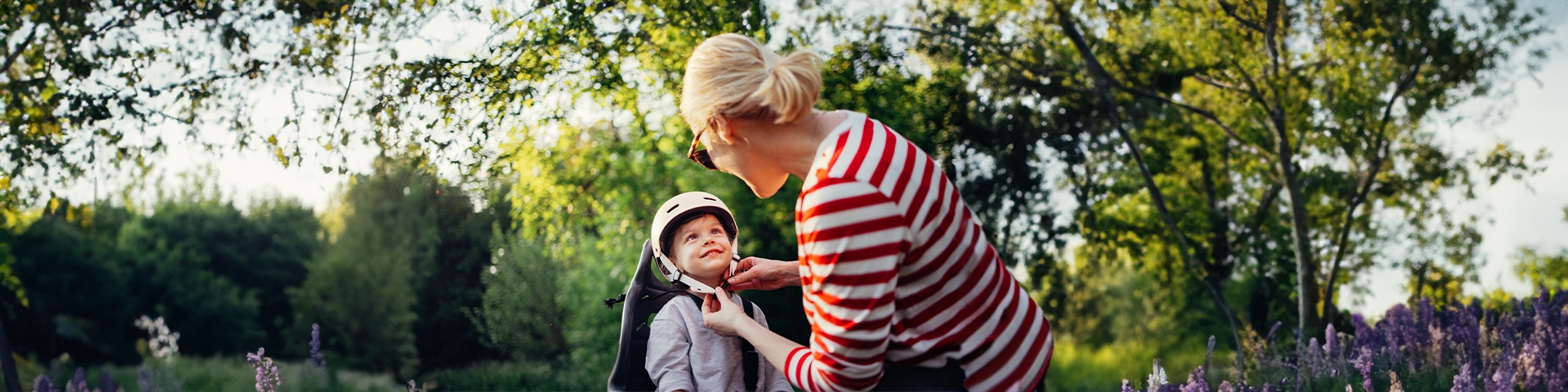 donna che allaccia il casco a un bambino in bici | Crédit Agricole donna che allaccia il casco a un bambino in bici | Crédit Agricole