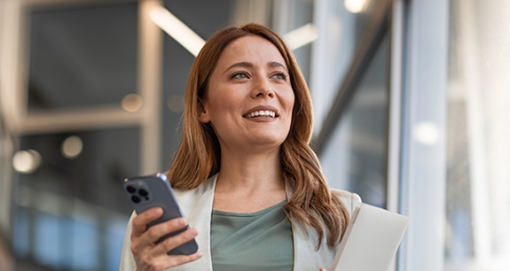 donna con smartphone in mano che guarda a destra | Crédit Agricole donna con smartphone in mano che guarda a destra | Crédit Agricole