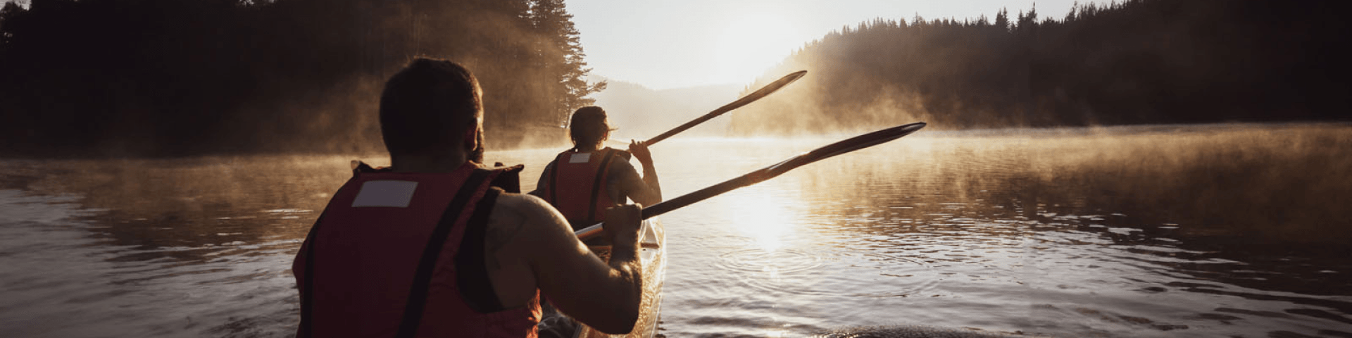 Due persone in canoa su un lago immerso nella natura al tramonto | Crédit Agricole Due persone in canoa su un lago immerso nella natura al tramonto | Crédit Agricole