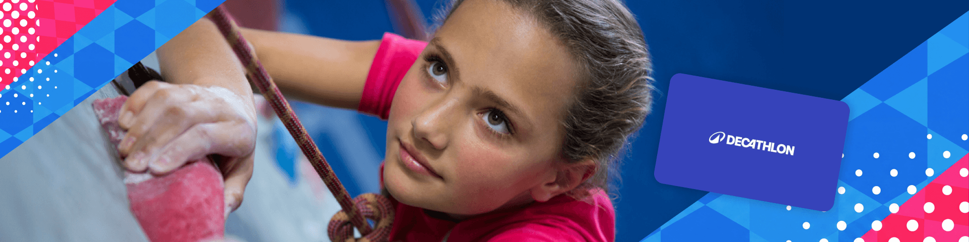 Primo piano di una bambina durante una sessione di arrampicata indoor; sulla destra è presente una gift card Decathlon. | Crédit Agricole Primo piano di una bambina durante una sessione di arrampicata indoor; sulla destra è presente una gift card Decathlon. | Crédit Agricole