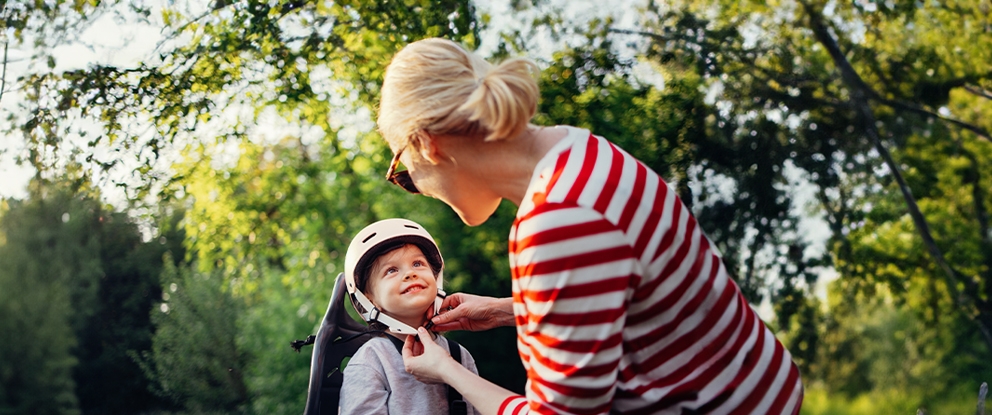 donna che allaccia il casco a un bambino in bici | Crédit Agricole donna che allaccia il casco a un bambino in bici | Crédit Agricole