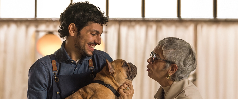 una signora anziana che da un bacio al cane che è tenuto in braccio da un uomo | Crédit Agricole una signora anziana che da un bacio al cane che è tenuto in braccio da un uomo | Crédit Agricole