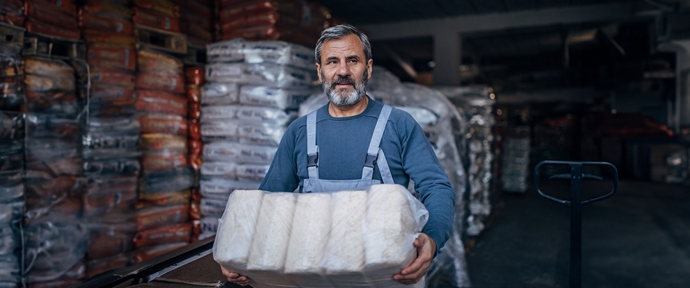 uomo in un magazzino con prodotti in mano | Crédit Agricole uomo in un magazzino con prodotti in mano | Crédit Agricole