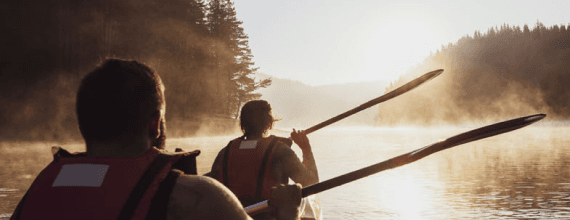 Due persone in canoa su un lago immerso nella natura al tramonto | Crédit Agricole Due persone in canoa su un lago immerso nella natura al tramonto | Crédit Agricole